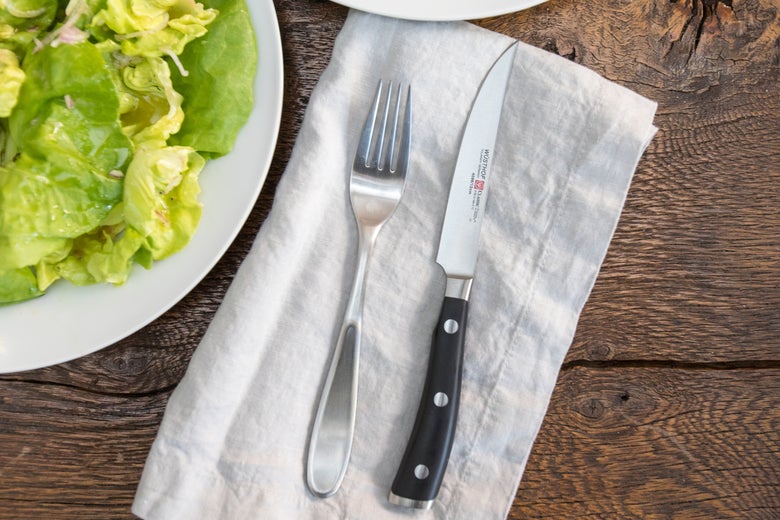 knife and fork next to a salad